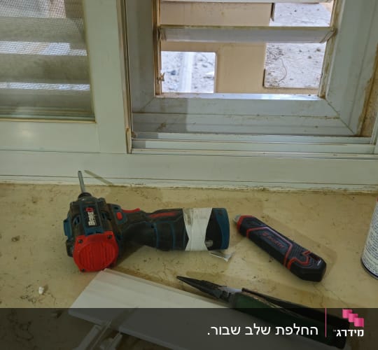 כלים וחלקים ליד חלון עם תריסים